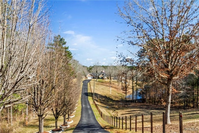 surrounding community with fence and aphalt driveway