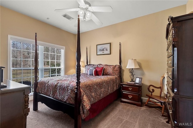 carpeted bedroom featuring ceiling fan and visible vents