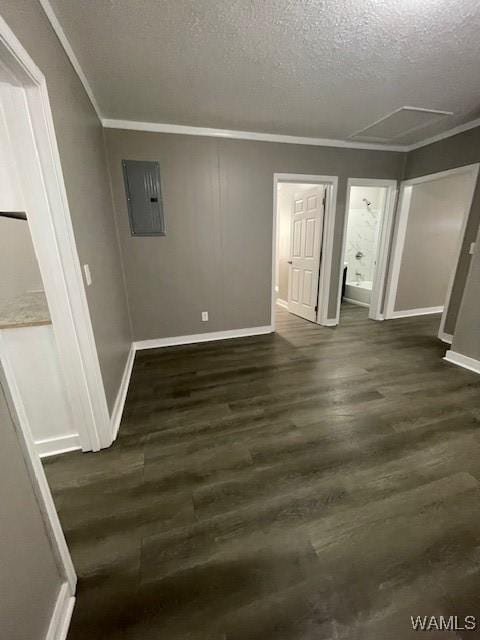 empty room featuring dark wood-style floors, crown molding, a textured ceiling, electric panel, and baseboards