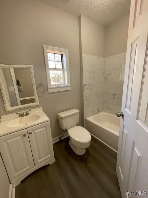 bathroom featuring a textured ceiling, toilet, wood finished floors, vanity, and washtub / shower combination