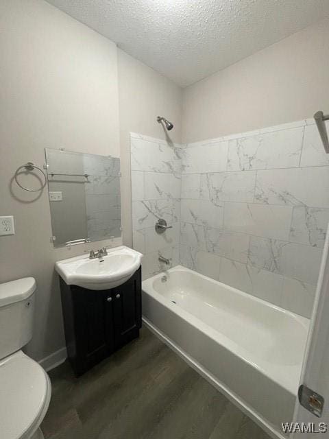 bathroom with toilet, wood finished floors, a textured ceiling, vanity, and shower / washtub combination