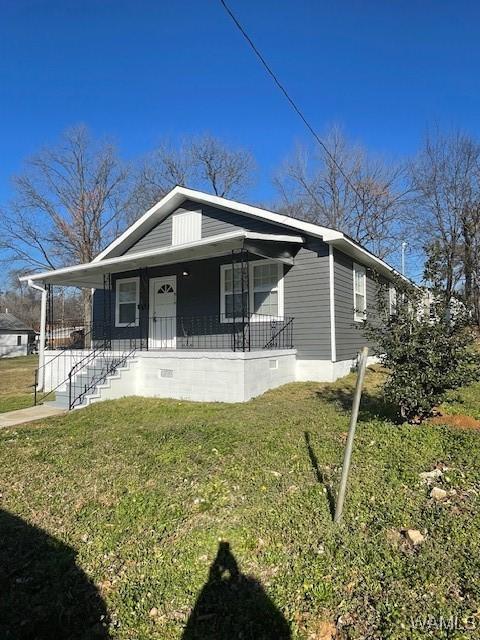 bungalow featuring covered porch, crawl space, and a front yard