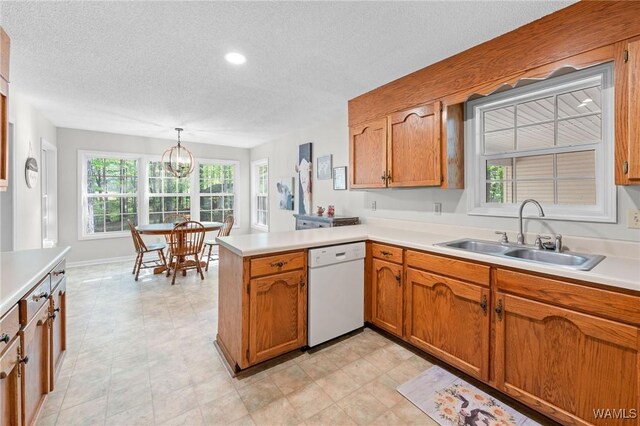 12863 N Country Dr, Tuscaloosa, AL 35475 - kitchen featuring a peninsula, a textured ceiling, brown cabinets, dishwasher, and a sink