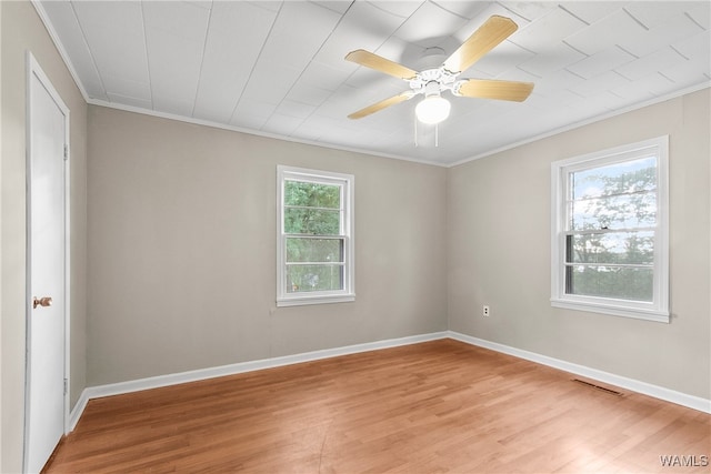 empty room featuring ornamental molding, light hardwood / wood-style floors, and a healthy amount of sunlight