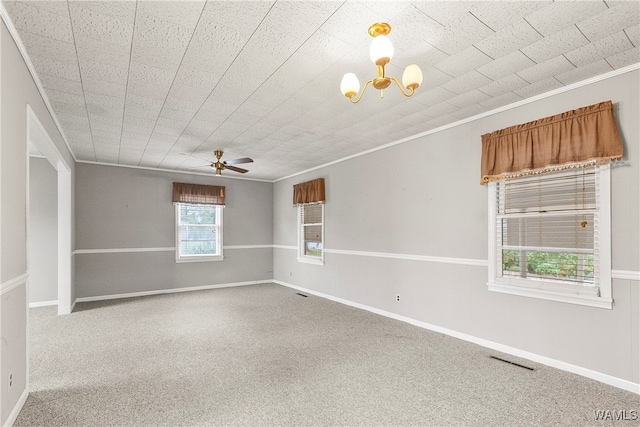 carpeted empty room featuring ceiling fan with notable chandelier and ornamental molding