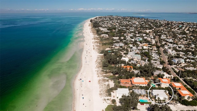 birds eye view of property with a water view and a beach view