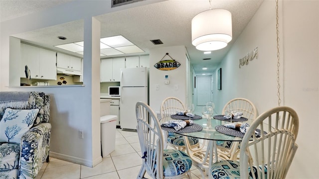 dining area with light tile floors and a textured ceiling