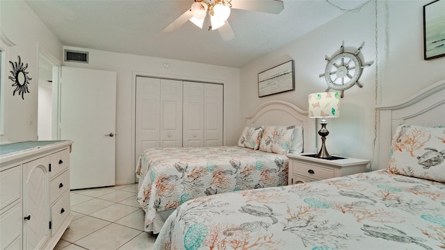 tiled bedroom featuring a closet, ceiling fan, and a textured ceiling