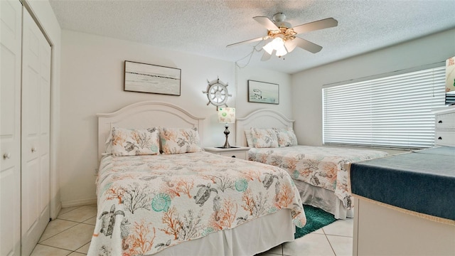 tiled bedroom with a textured ceiling, a closet, and ceiling fan