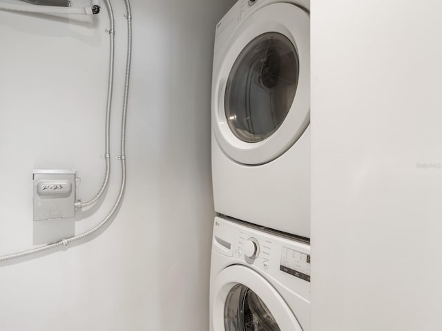 washroom with stacked washing maching and dryer