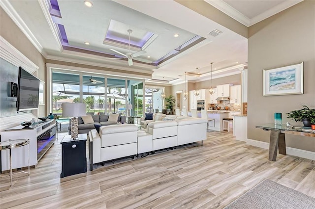 living room featuring light hardwood / wood-style flooring, a tray ceiling, ceiling fan, and crown molding