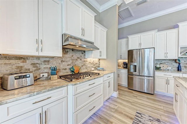 kitchen with stainless steel appliances, light stone countertops, tasteful backsplash, white cabinetry, and crown molding