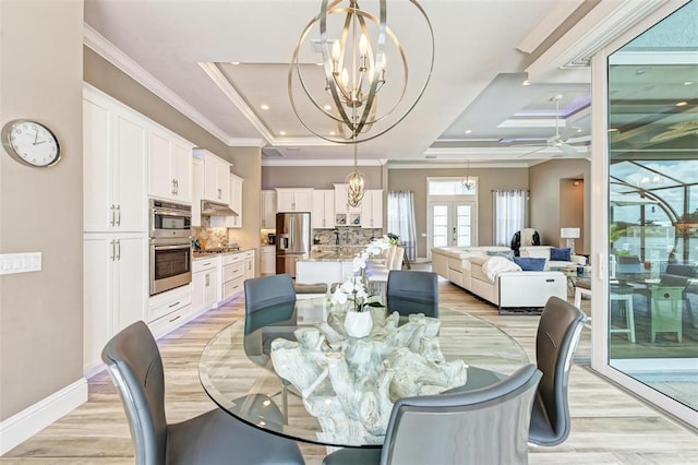 dining area featuring a tray ceiling, ceiling fan with notable chandelier, sink, light hardwood / wood-style flooring, and ornamental molding