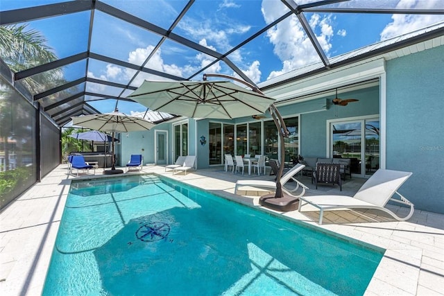 view of pool with outdoor lounge area, a patio, ceiling fan, and a lanai