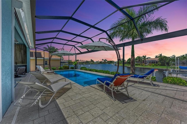 pool at dusk with a water view, a lanai, and a patio area