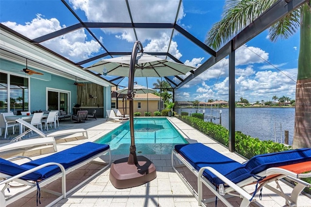 view of swimming pool featuring a water view, a patio, ceiling fan, and glass enclosure