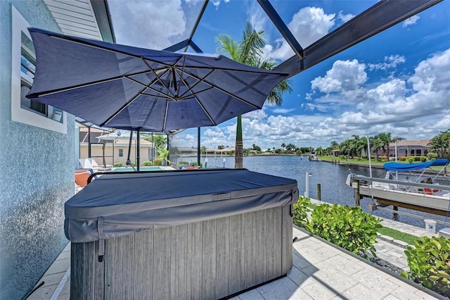 view of patio / terrace with a water view and a hot tub