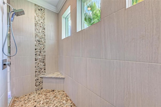 bathroom featuring ornamental molding and tiled shower