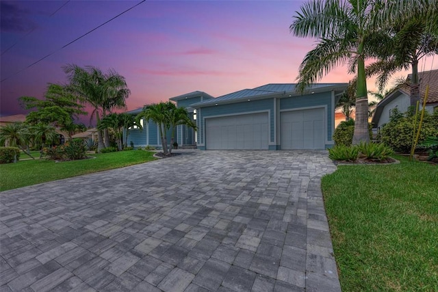 view of front of home featuring a lawn and a garage