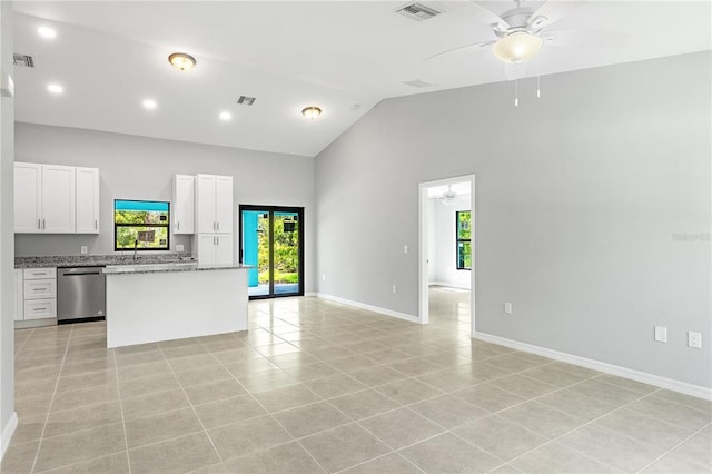 kitchen with ceiling fan, light stone counters, stainless steel dishwasher, light tile flooring, and white cabinetry