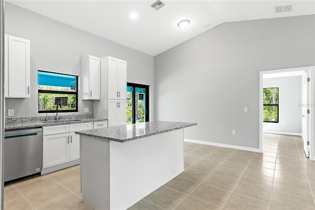 kitchen with sink, a kitchen island, white cabinets, dishwasher, and light stone countertops