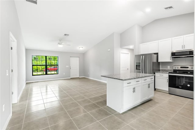 kitchen with ceiling fan, appliances with stainless steel finishes, light tile floors, white cabinets, and vaulted ceiling