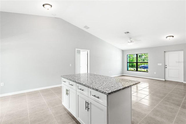 kitchen featuring white cabinetry, lofted ceiling, ceiling fan, light tile floors, and a kitchen island