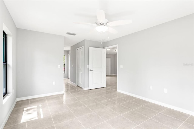 tiled spare room featuring ceiling fan