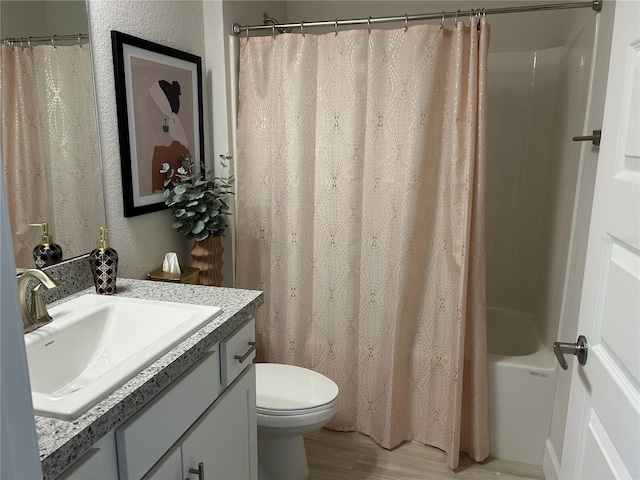 full bathroom featuring hardwood / wood-style floors, vanity, toilet, and shower / tub combo with curtain