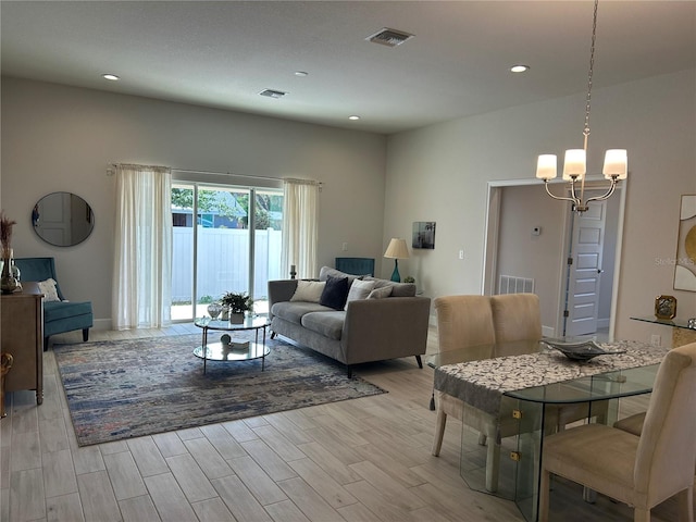 living room with a notable chandelier and light wood-type flooring