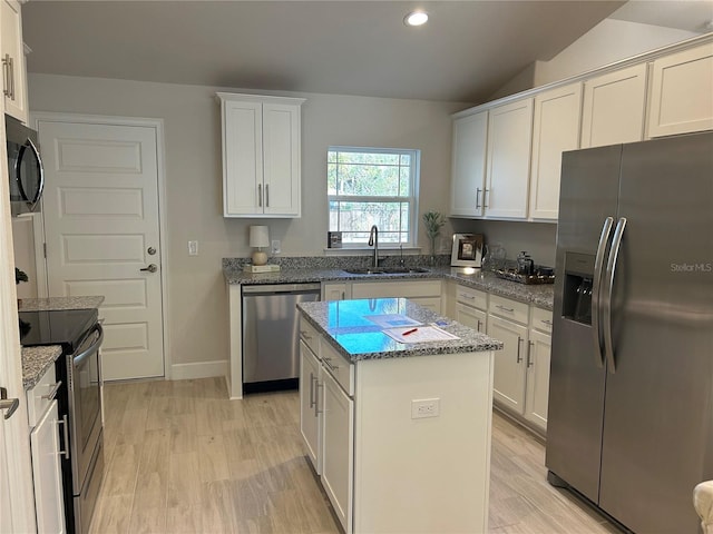 kitchen with a center island, white cabinets, sink, light hardwood / wood-style flooring, and stainless steel appliances