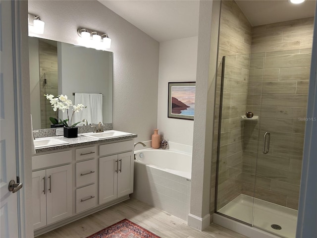 bathroom with hardwood / wood-style flooring, vanity, and separate shower and tub