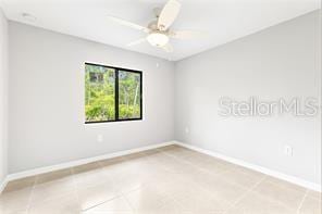 tiled empty room with ceiling fan