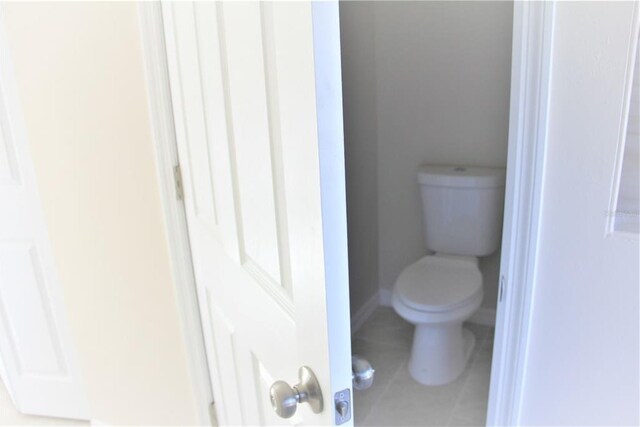 bathroom featuring tile flooring and toilet