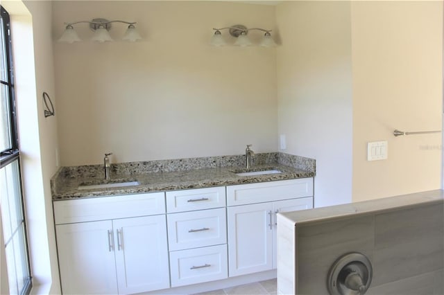 bathroom with double sink vanity, tile floors, and a wealth of natural light