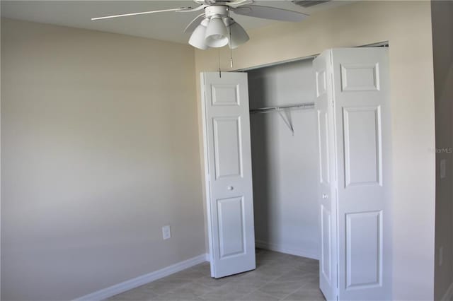 unfurnished bedroom featuring ceiling fan, light tile floors, and a closet