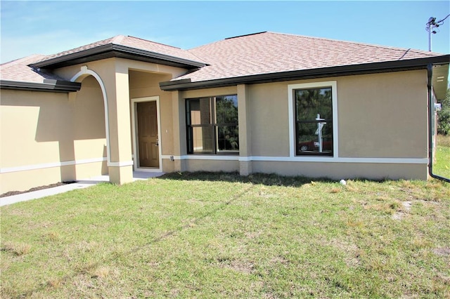 rear view of property featuring a yard