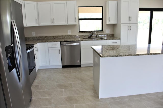 kitchen featuring white cabinets, stone counters, plenty of natural light, and stainless steel appliances