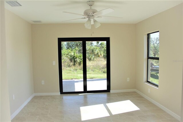 empty room with light tile floors and ceiling fan