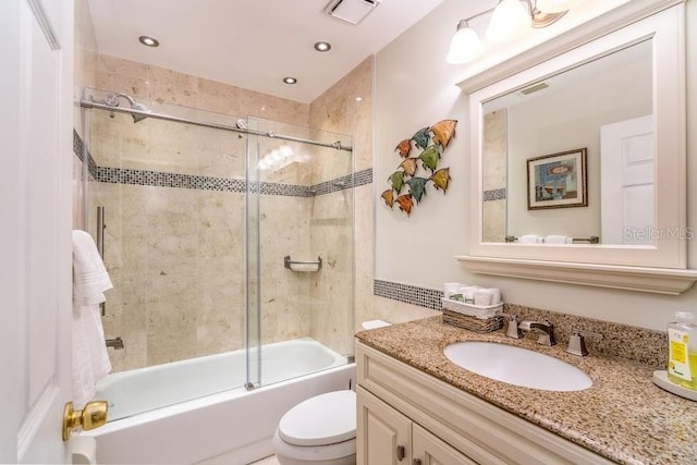 full bathroom featuring vanity, bath / shower combo with glass door, and toilet