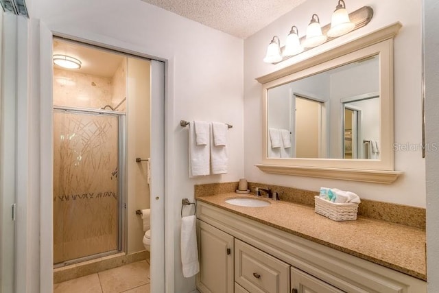 bathroom featuring walk in shower, vanity, tile patterned flooring, and a textured ceiling