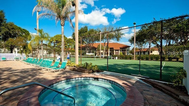 view of swimming pool featuring tennis court and a community hot tub