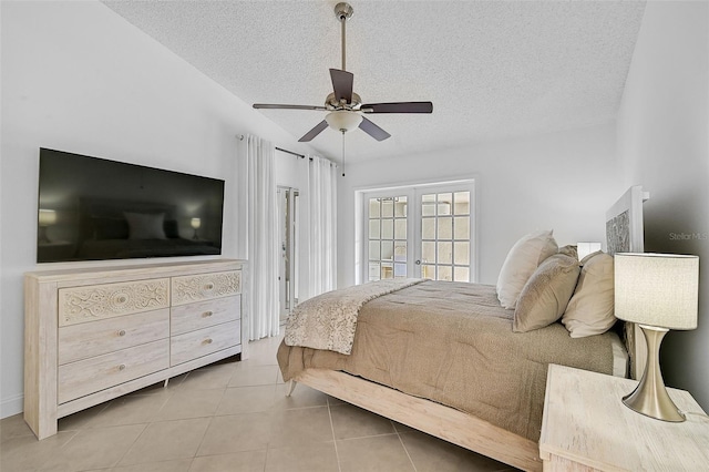 tiled bedroom featuring a textured ceiling, ceiling fan, vaulted ceiling, and french doors