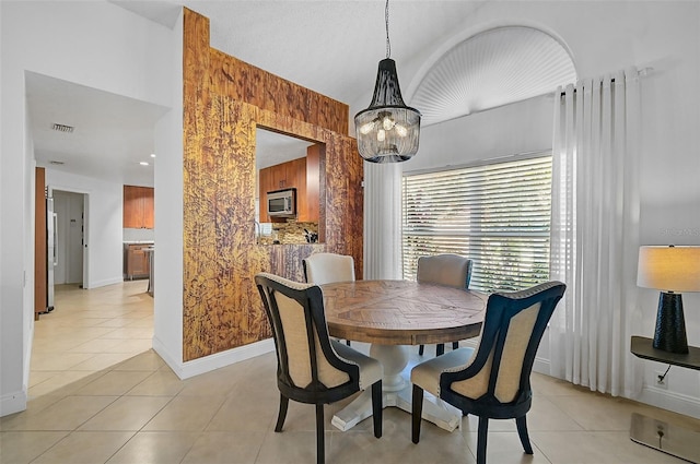 tiled dining room featuring a notable chandelier and wooden walls