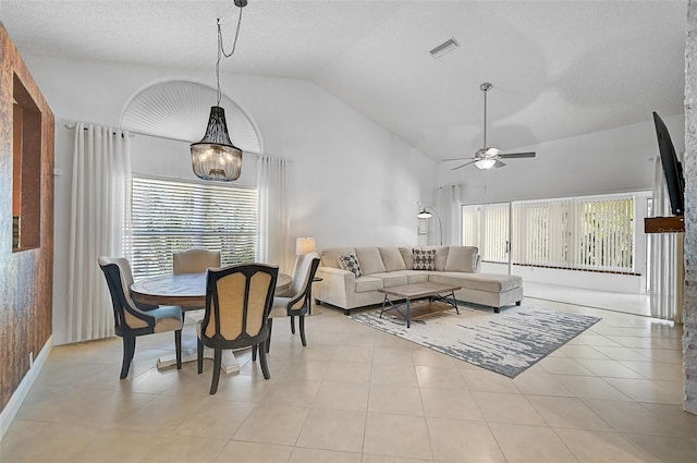 living room featuring light tile patterned floors, vaulted ceiling, ceiling fan with notable chandelier, and a textured ceiling