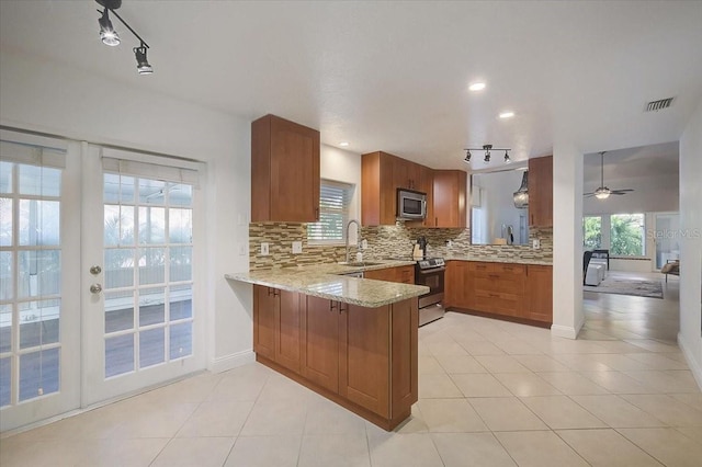 kitchen featuring appliances with stainless steel finishes, sink, backsplash, kitchen peninsula, and light tile patterned floors