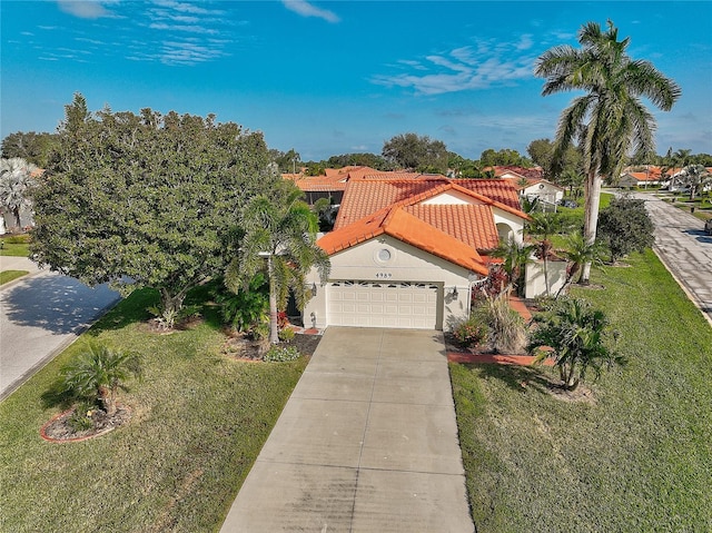 mediterranean / spanish home with a front yard and a garage