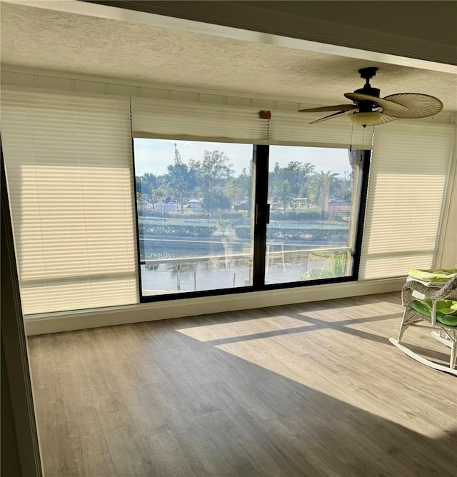 unfurnished sunroom featuring plenty of natural light and ceiling fan