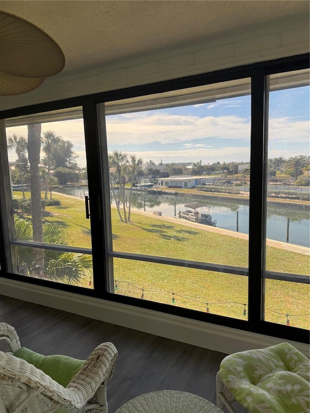 sunroom featuring a water view