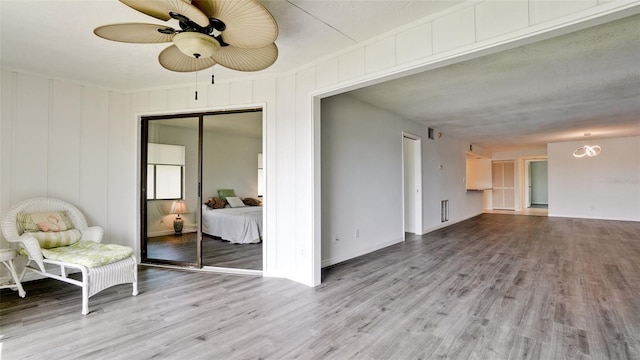 unfurnished living room with wood-type flooring and ceiling fan